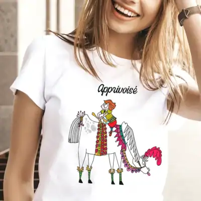 T-shirt femme blanc illustré « Apprivoisé » porté, illustration poétique Abi Illustration représentant une femme à cheval, style doux et coloré, vêtement féminin confortable et lumineux