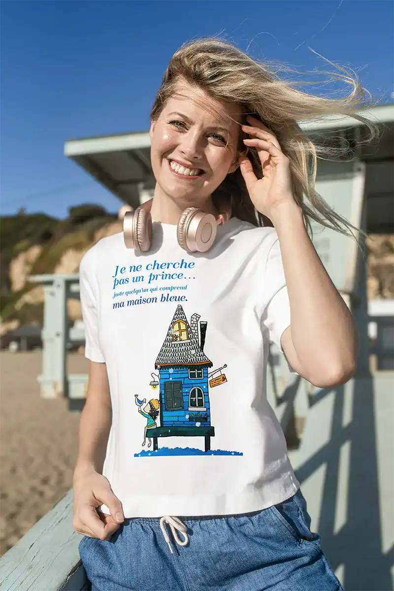 t-shirt femme blanc porté illustration maison bleue Abi Illustration, message poétique « Je ne cherche pas un prince juste quelqu’un qui comprend ma maison bleue », t-shirt message femme, vêtement féminin illustré, t-shirt poétique, cadeau femme original