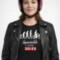 Femme portant le t-shirt Impossible n’est pas Solex noir avec blouson motard et casque rétro rouge