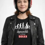 Femme portant le t-shirt Impossible n’est pas Solex noir avec blouson motard et casque rétro rouge