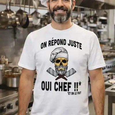 Homme en cuisine de restaurant portant un t-shirt blanc humour “On répond juste oui chef” avec tête de mort chef imprimée