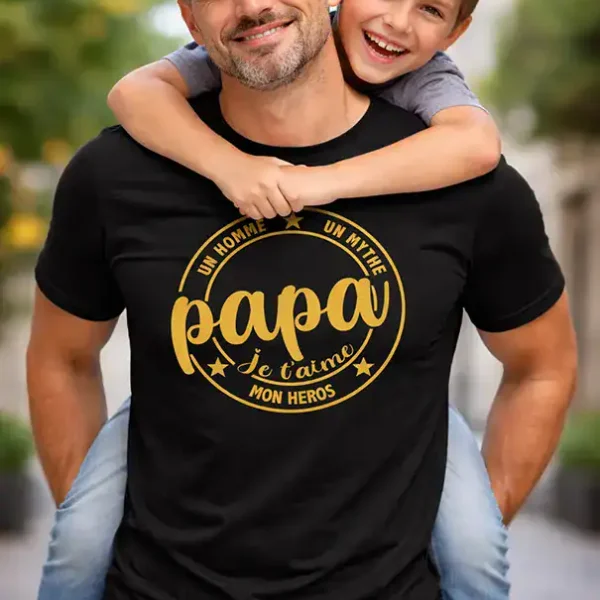 t shirt papa je t aime mon heros noir impression dtf couleur or porté par un père avec sa fille sourire fond extérieur flou