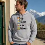 Sweat à capuche gris eat sleep cat repeat porté par homme en extérieur montagne