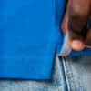 Main ajustant un polo bleu sur jean clair