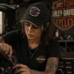 Casquette noire Dream Vallée Chapter France portée par femme style biker en garage moto