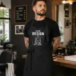 Barbier portant un tablier noir personnalisé avec logo texte ou photo dans un salon professionnel premium