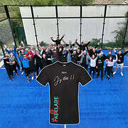 Groupe souriant en tenue de sport sur un terrain de padel.