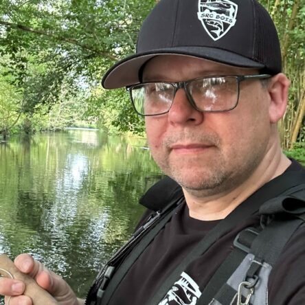 Homme avec casquette pêchant au bord d'une rivière