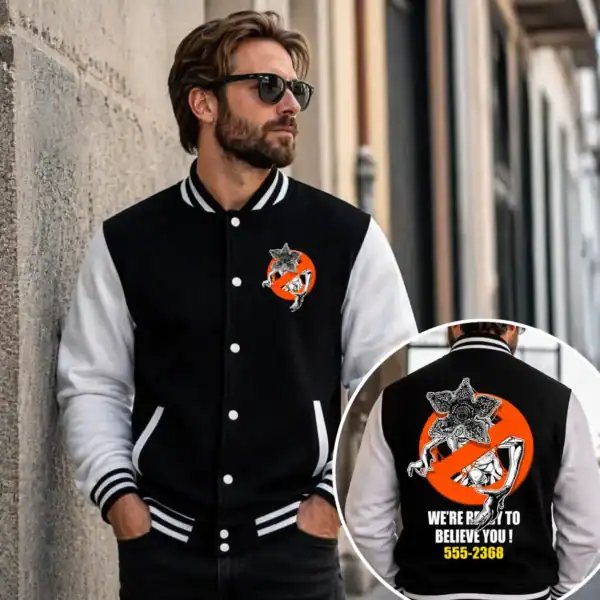 veste varsity noir et blanc avec créature barrée dans un cercle orange portée par homme en extérieur urbain