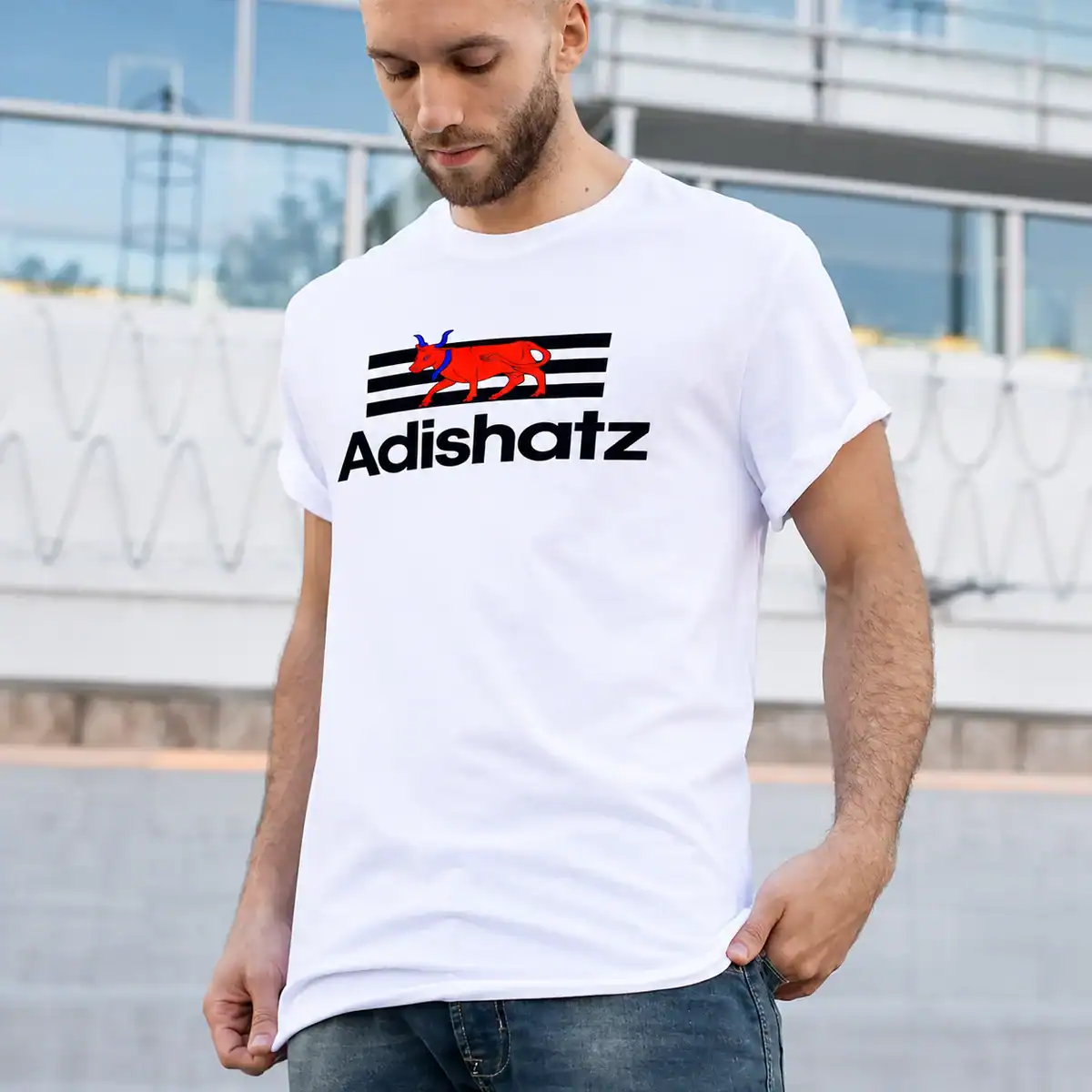Homme portant un t-shirt blanc Adishatz Béarn avec motif vache rouge et bandes noires, création textile béarnaise Pilou Shop 64.