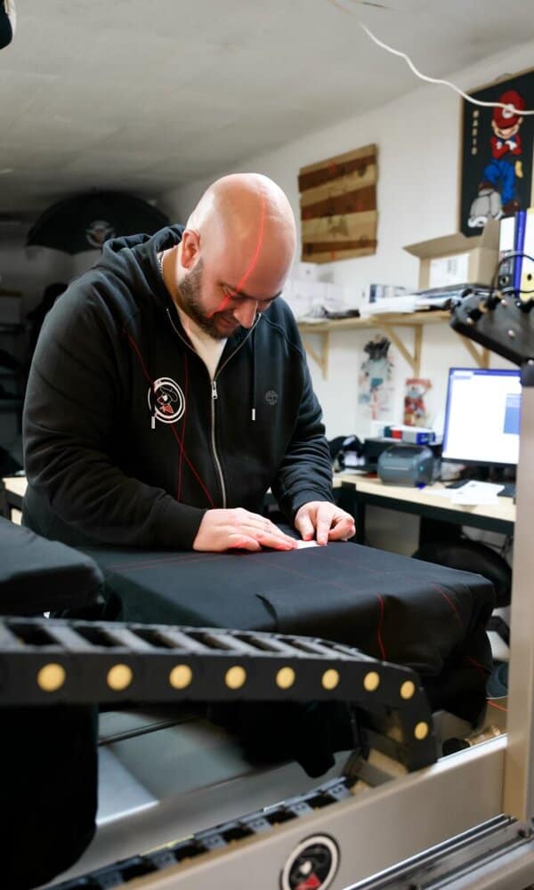 Personne travaillant sur un textile avec des lignes rouges.