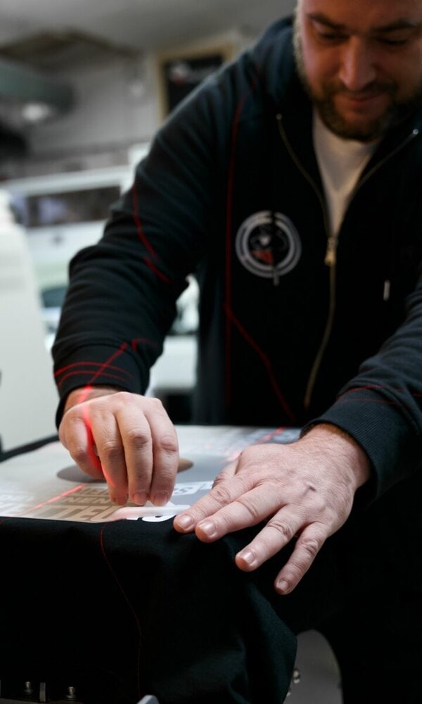 Homme travaillant sur un vêtement avec un modèle.