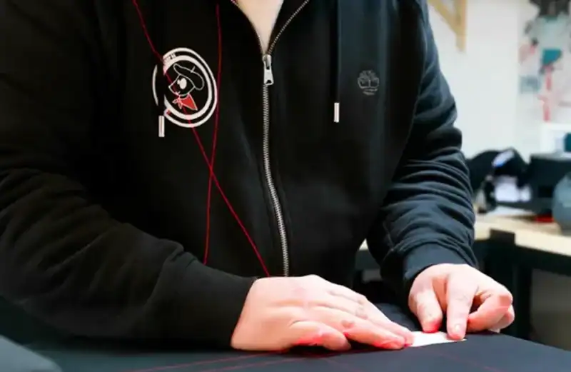 artisan en atelier de personnalisation textile préparant un marquage et choisissant la technique adaptée