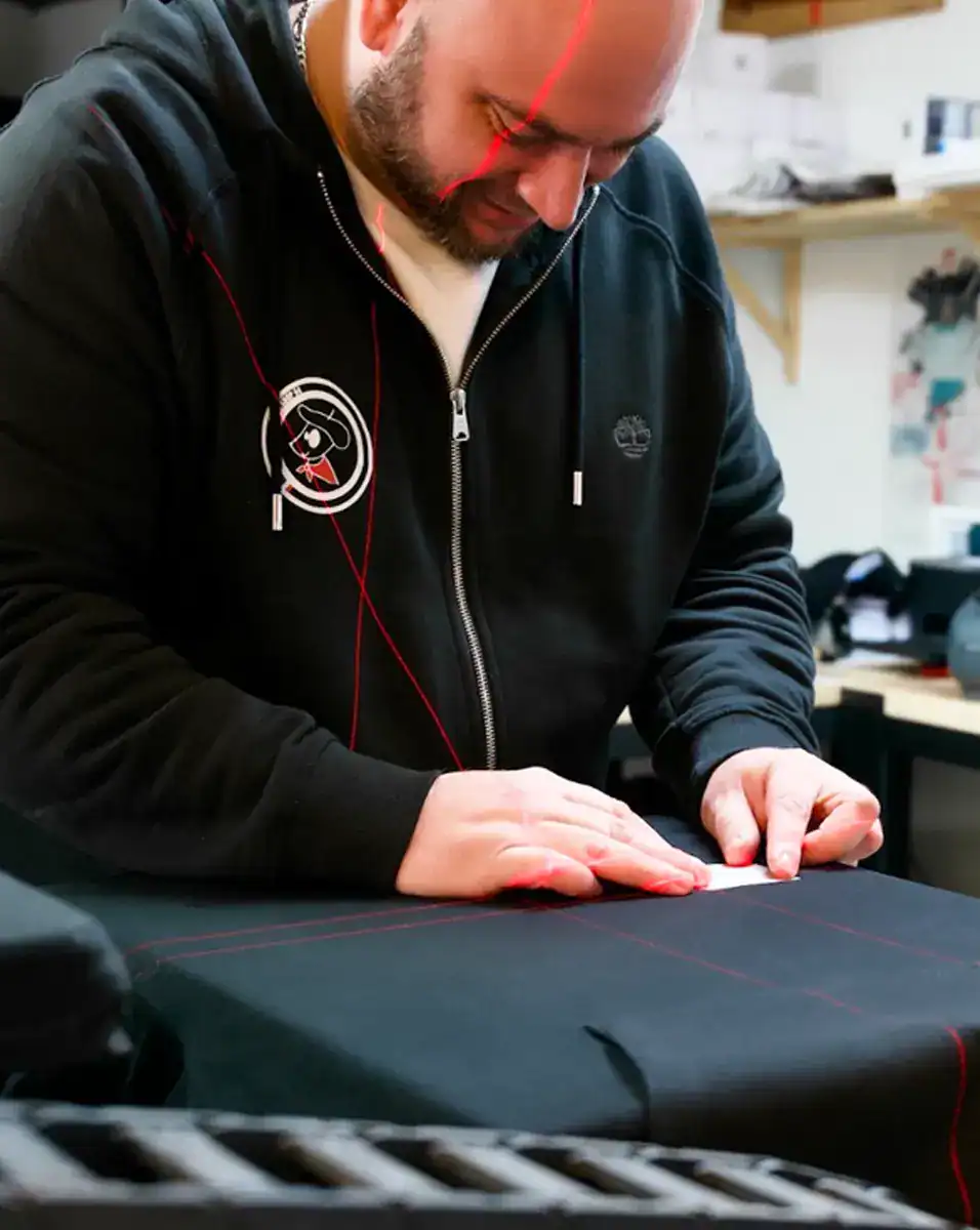 artisan en atelier de personnalisation textile préparant un marquage et choisissant la technique adaptée