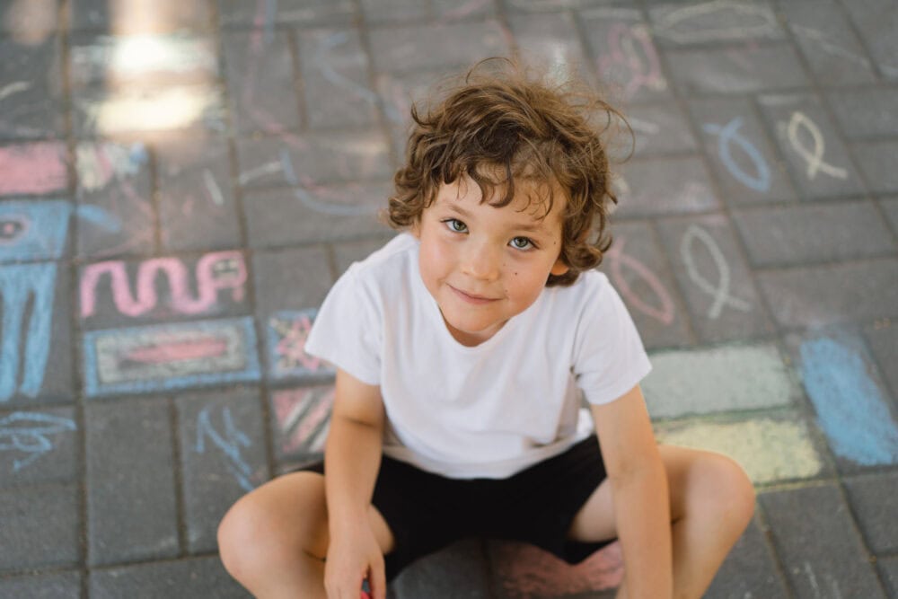 Enfant avec skateboard sur fond bleu