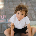 Enfant avec skateboard sur fond bleu