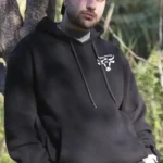Homme portant sweat noir Paysans d’Occitanie 65 logo blanc poitrine extérieur campagne
