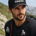 homme portant une casquette noire Adishatz avec visuel béarnais et homme sportif en montagne portant la même casquette Pilou Shop 64