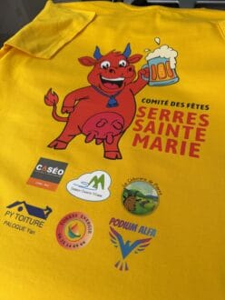 T-shirt jaune personnalisé du Comité des Fêtes de Serres-Sainte-Marie avec mascotte rouge tenant une bière et logos des partenaires locaux réalisé par Pilou Shop 64 à Pau.