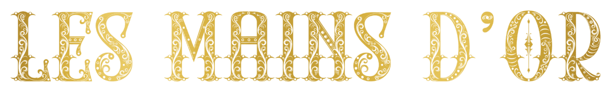 Logo officiel Les Mains d’Or en lettres dorées sur fond blanc pour la collection de vêtements du salon de tatouage à Pau