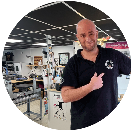 Homme souriant montrant logo dans atelier d’impression