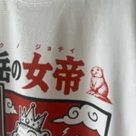 Zoom sur l’impression DTF du t-shirt Queen of Béarn avec les caractères japonais et la marmotte couronnée, marquage haute définition réalisé à Pau.