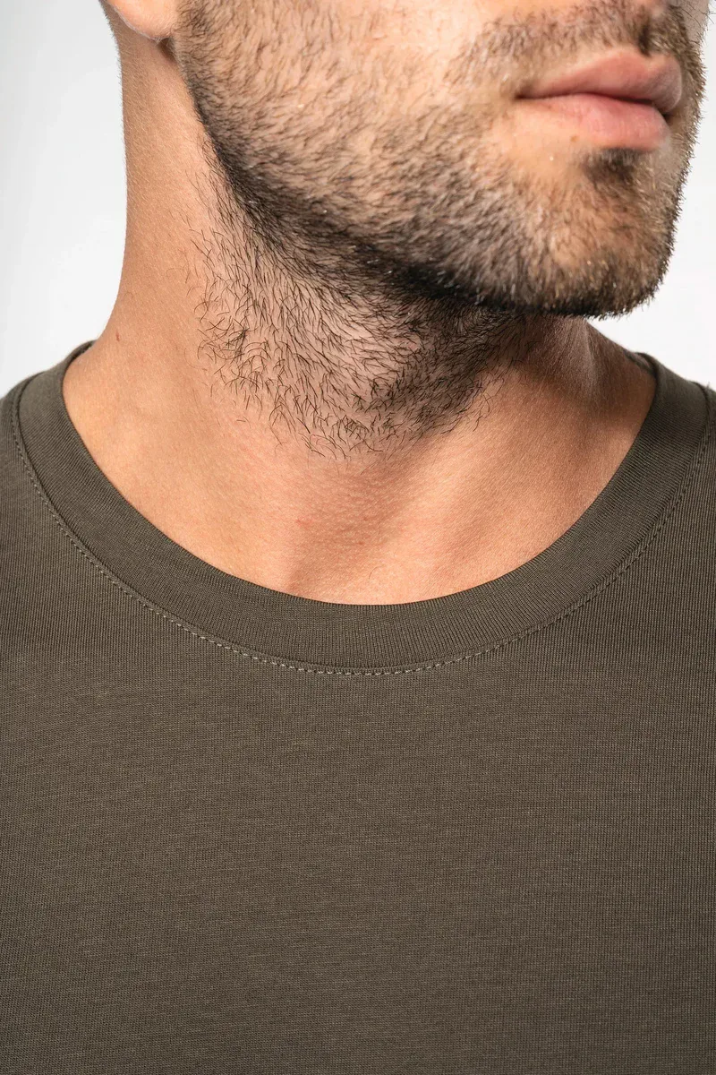 Détail du col rond d’un t-shirt homme manches longues kaki porté par un homme barbu.